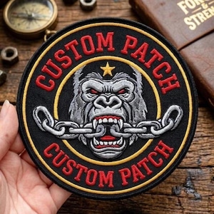 Puede incluir: Parche personalizado bordado con un gorila con una cadena en la boca. El parche es redondo, con las palabras "CUSTOM PATCH" en rojo alrededor del borde. El gorila es gris y blanco, con ojos rojos y una estrella dorada encima.