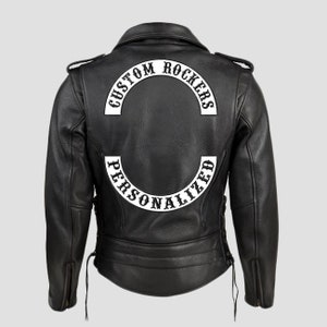 Könnte beinhalten: Schwarze Lederjacke für Motorradfahrer mit einem weißen gestickten Aufnäher auf der Rückseite, auf dem "Custom Rockers Personalized" steht.