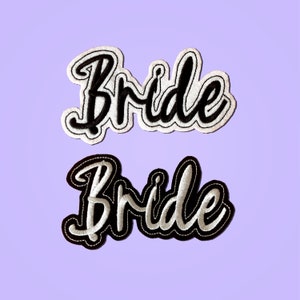 Puede incluir: Dos parches bordados blancos y negros con la palabra "Bride" en una fuente cursiva.