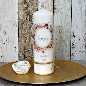 Könnte beinhalten: Weiße Kerze mit floralem Design und dem Namen "Tammy" sowie dem Datum "18.04.2022" darauf gedruckt. Im Vordergrund befindet sich eine kleine, weiße, dekorative Rose.
