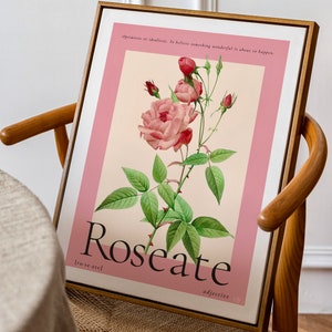 floral art print in pink featuring a large budding rose sits in a wooden frame on a mid-century chair in a dining room