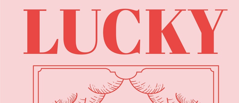 Close up of Lucky art is pink and red and inspired by retro tarot art. At the bottom of the art, retro red typography reads LUCKY YOU