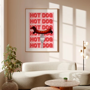 Printable pink & red dog art print. Soft pink background with red text in the style of neon lights reading HOT DOG. in the centre of the art print is a dachshund in the shape of a sausage on the end of a silver fork in a playful style hangs on wall
