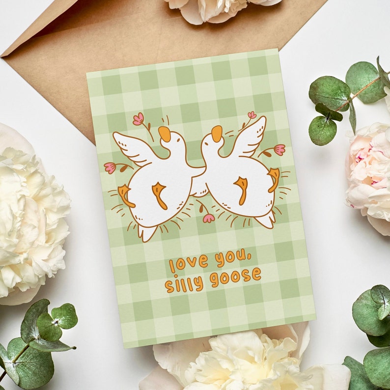 printable silly goose card. soft gingham background with two geese lying on their backs surrounded by flowers. text reads love you silly goose. Printable anniversary card for boyfriend or girlfriend