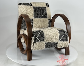 May include: A wooden armchair with a unique curved design and a black and white patterned cushion. The cushion is made of a soft, fluffy material.