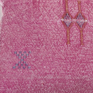 May include: Pink throw pillow with a woven design featuring geometric shapes in brown and gray.