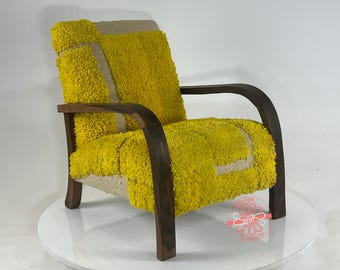 Puede incluir: Un sillón amarillo y blanco con marco de madera. El sillón tiene una tapicería de tela texturizada única.