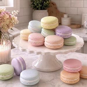 May include: A collection of pastel-colored macarons arranged on a white scalloped cake stand. The macarons feature shades of pale yellow, light blue, soft pink, lavender, and mint green, each with a visible white cream filling between two shells.