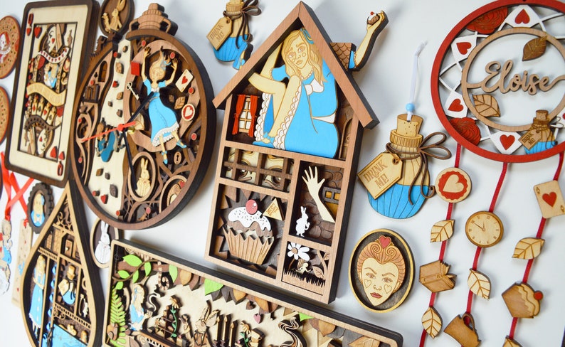 K&ouml;nnte beinhalten: Eine Sammlung von Holzdekorationen mit Laserschnitt, die Charaktere und Szenen aus Alice im Wunderland zeigen. Enth&auml;lt eine Uhr, ein Haus, eine Flaschen- und Spielkarten-Designs. Die Farbpalette umfasst Braun-, Blau-, Rot- und Wei&szlig;t&ouml;ne.
