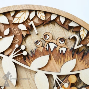 May include: Close-up of a wooden wall clock with a bird's nest design. The clock face features the numbers 1 and 2, with a carved bird's nest and birds in the center. The clock is made of light brown wood with a natural wood grain.