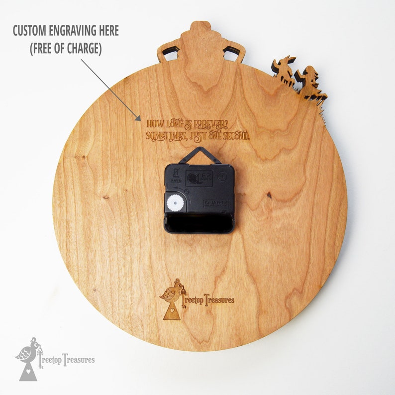 K&ouml;nnte beinhalten: Eine Holzuhr mit hellbraunem Finish. Die Uhr hat ein schwarzes Uhrwerk und den Text "HOW LONG IS FOREVER? SOMETIMES, JUST ONE SECOND." Die Uhr hat eine kronenf&ouml;rmige Oberseite und ein dekoratives Element auf der rechten Seite.