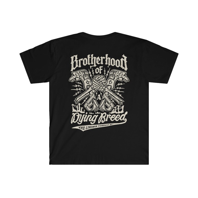 Op de afbeelding: Zwart T-shirt met een wit grafisch ontwerp van twee skeletachtige handen die een moersleutel vasthouden met de tekst "Brotherhood of a Dying Breed" en "The Lineman Company" eronder.