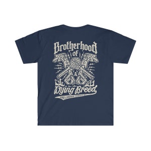 Op de afbeelding: Donkerblauw T-shirt met een witte afbeelding van twee skeletachtige handen die een moersleutel vasthouden, met de tekst "Brotherhood of a Dying Breed" en "The Lineman Company" eronder.