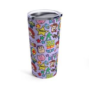 K&ouml;nnte beinhalten: Ein lilafarbener Edelstahlbecher mit einem sich wiederholenden Muster von Toy Story-Charakteren und S&auml;tzen, darunter "You've Got a Friend in Me" und "To Infinity and Beyond".