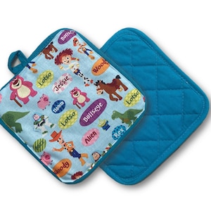 May include: Two square pot holders. One features a light blue background with cartoon characters and character names. The other is solid teal with a quilted pattern. Both have teal trim and a teal loop for hanging.