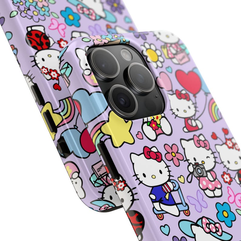 May include: A purple phone case with a repeating pattern of Hello Kitty characters, rainbows, stars, and hearts. The case has a cutout for the camera lens.