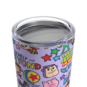 K&ouml;nnte beinhalten: Ein lilafarbener Edelstahlbecher mit einem bunten Muster aus Toy Story-Charakteren und S&auml;tzen, darunter "Unendlich und dar&uuml;ber hinaus", "Du hast einen Freund in mir" und "Die Klammer!"
