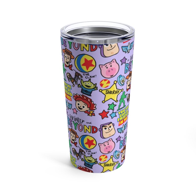 K&ouml;nnte beinhalten: Ein lilafarbener Edelstahlbecher mit einem sich wiederholenden Muster von Toy Story-Charakteren, darunter Woody, Buzz Lightyear, Jessie und der Au&szlig;erirdische. Der Text "Infinity and Beyond" wird auf dem Becher wiederholt.