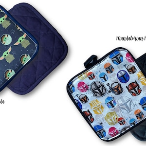 May include: Two square pot holders. One features a pattern of Baby Yoda with stars on a navy background. The other has a navy quilted design. The second set has a Mandalorian helmet pattern on a white background and a black quilted design.