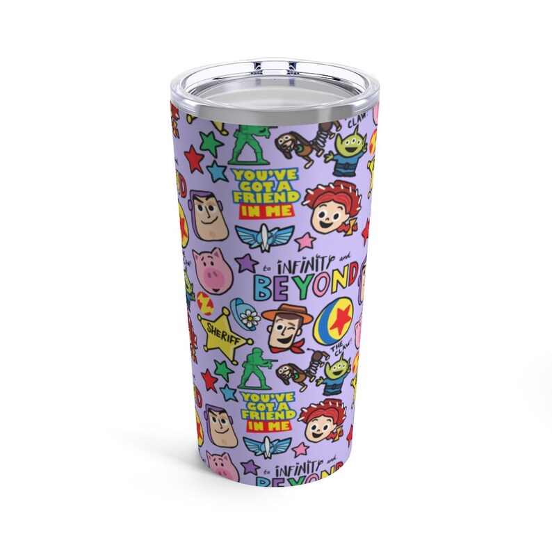 K&ouml;nnte beinhalten: Ein lilafarbener Edelstahlbecher mit einem sich wiederholenden Muster von Toy Story-Charakteren und dem Text "You've got a friend in me" und "To infinity and beyond".