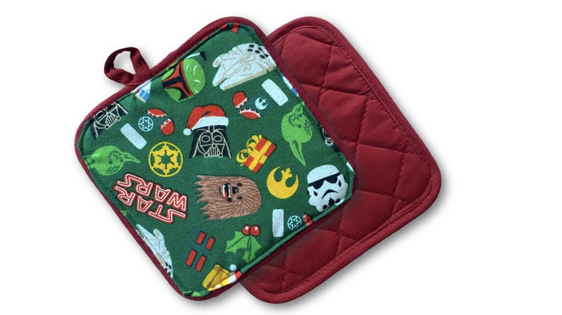 May include: Two square pot holders. One is a quilted solid burgundy. The other is green with Star Wars characters and holiday icons. The pot holder has a burgundy trim and a loop for hanging.