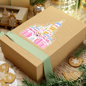 May include: A brown gift box with a green ribbon and a sticker of a pink and white castle with a number 25 on it.
