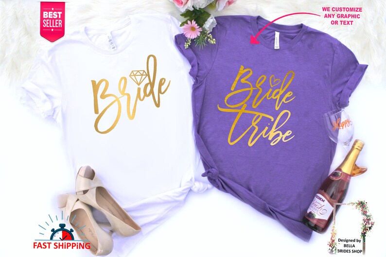 May include: Two white t-shirts with gold lettering. One shirt says "Bride" with a diamond graphic. The other shirt says "Bride Tribe".