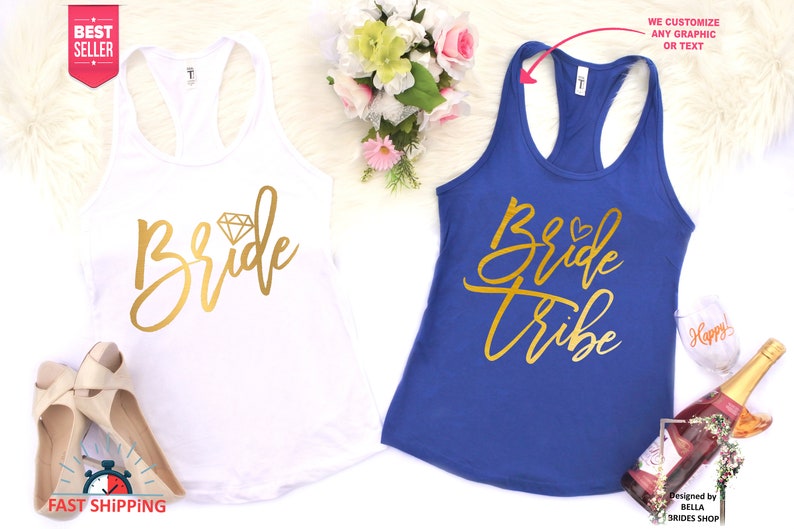 May include: Two white tank tops with gold lettering. The top on the left says "Bride" with a diamond graphic. The top on the right says "Bride Tribe".