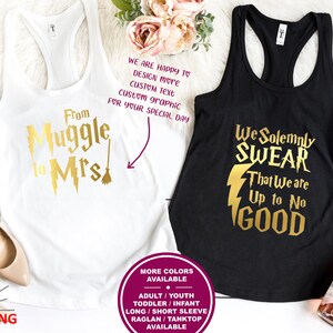 May include: Two tank tops with gold text and graphics. The white tank top says "From Muggle to Mrs." with a lightning bolt and a broom. The black tank top says "We Solemnly Swear That We Are Up to No Good" with a lightning bolt.
