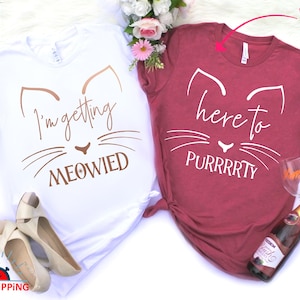 May include: Two white t-shirts with a cat graphic and the text "I'm getting MEOWIED" and "here to PURRRRTY".