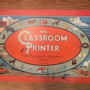 May include: A vintage board game box with a red background and a circular image of a classroom printer. The text "The Classroom Printer" is in large, bold letters. The box is decorated with illustrations of animals, buildings, and other objects.