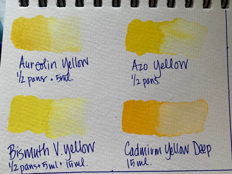 May include: Four watercolor paint swatches on a white paper background. The swatches are labeled with the names of the colors: Aureolin Yellow, Azo Yellow, Bismuth V. Yellow, and Cadmium Yellow Deep. The amount of paint used for each swatch is also listed.