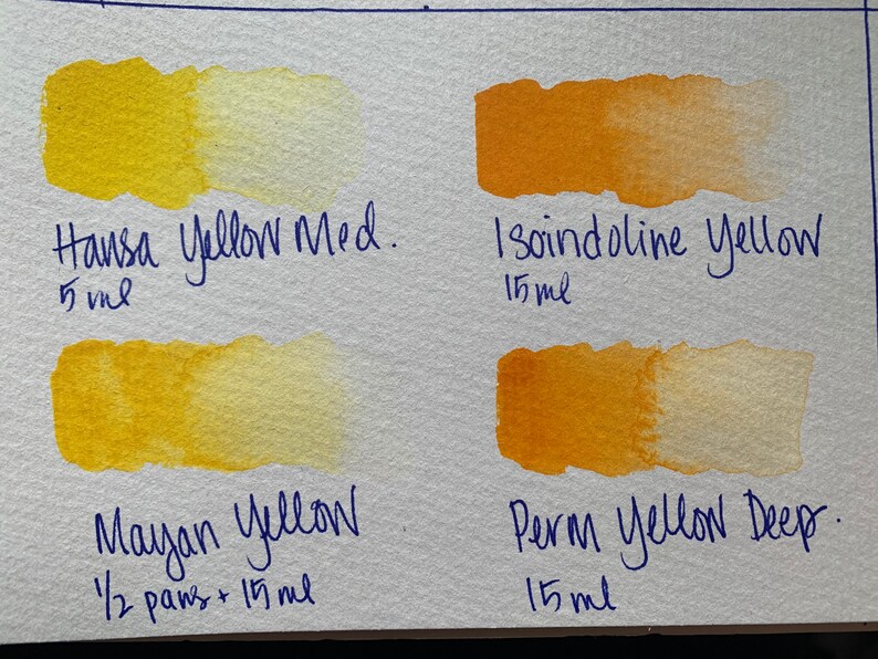 May include: Four watercolor paint swatches on a white surface. The swatches are labeled "Hansa Yellow Med. 5ml", "Mayan Yellow 1/2 pans + 15ml", "Isoindoline Yellow 15ml", and "Perm Yellow Deep 15ml".