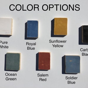 May include: Color options for a product, shown as painted wood squares. The colors are: Pure White, Royal Blue, Sunflower Yellow, Carbon Black, Ocean Green, Salem Red, and Soldier Blue.