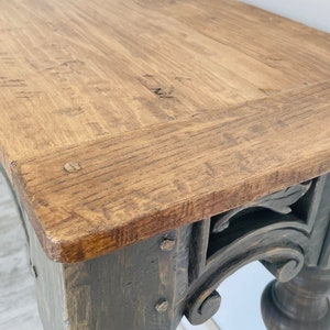 Peut inclure: Une console en bois rustique avec une base fonc&eacute;e et des sculptures complexes. Le plateau de la table est en bois naturel avec une finition brun clair.