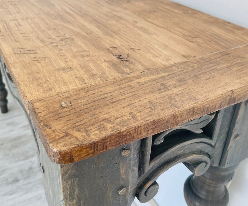 Peut inclure: Une console en bois rustique avec une base fonc&eacute;e et des sculptures complexes. Le plateau de la table est en bois naturel avec une finition brun clair.