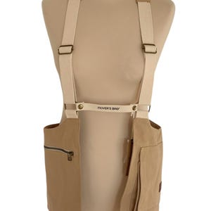 May include: A tan canvas utility vest with adjustable straps and a zippered pocket. The vest has the text "MOVER'S BAG" printed on the front.