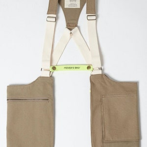 May include: A brown canvas utility bag with two pockets and adjustable straps. The straps are white with a green label that reads "MOVER'S BAG".