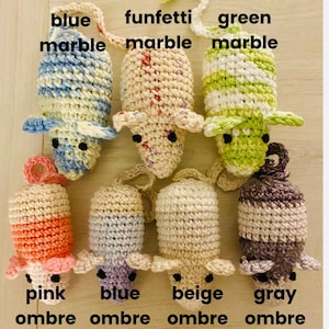 May include: A collection of handmade crochet mouse toys in various colors. The mice are in blue marble, funfetti marble, green marble, pink ombre, blue ombre, beige ombre, and gray ombre. Each mouse has small black eyes and a loop for hanging.