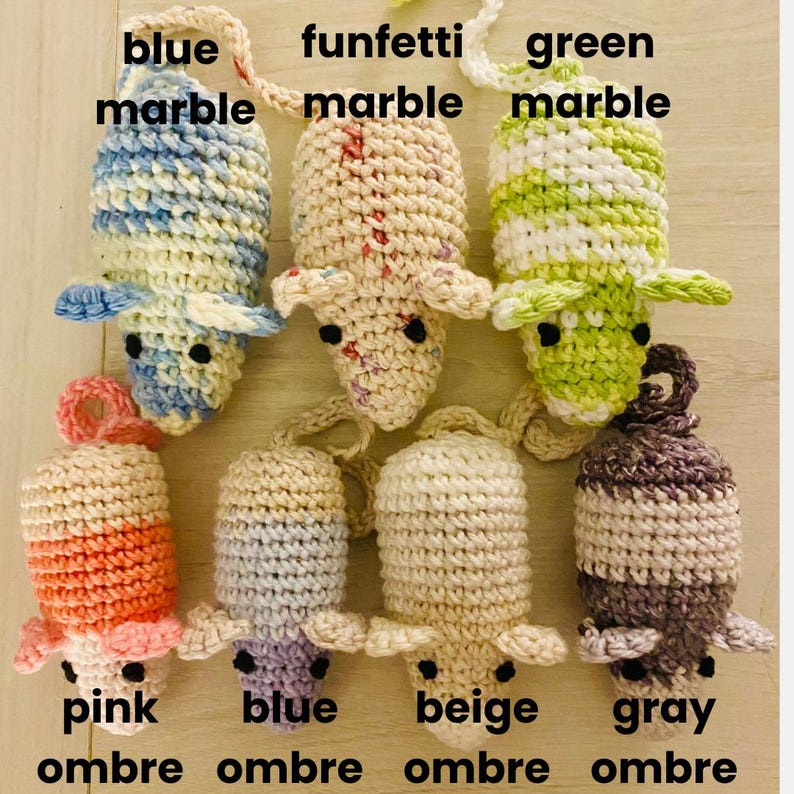 May include: A collection of handmade crochet mouse toys in various colors. The mice are in blue marble, funfetti marble, green marble, pink ombre, blue ombre, beige ombre, and gray ombre. Each mouse has small black eyes and a loop for hanging.
