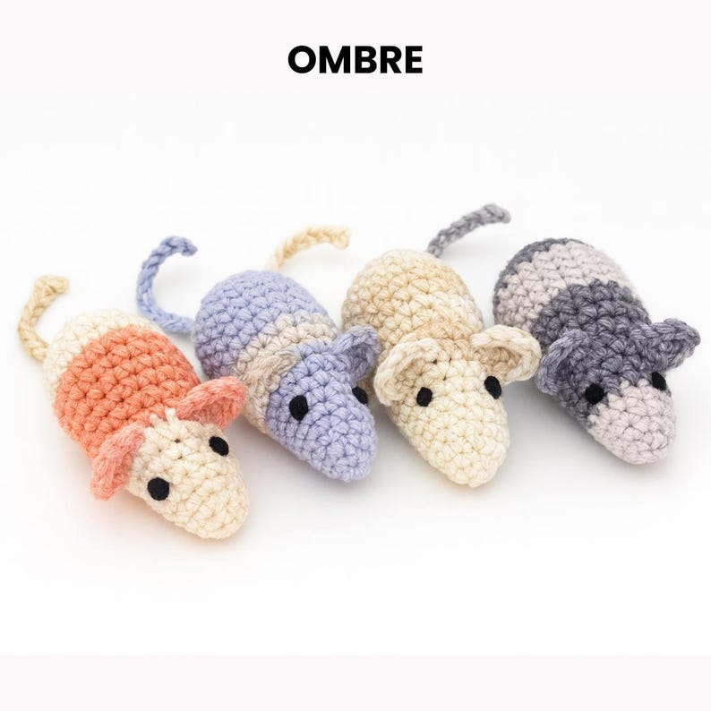 May include: Four crocheted toy mice in a row, each with a different color scheme. The mice have small ears, black eyes, and curled tails. The text "OMBRE" is at the top.