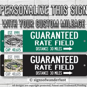 May include: Black and green metal sign with white text that reads "GUARANTEED RATE FIELD" with a small image of a baseball stadium and the text "EST. 1991 CAP. 40,615" below the image. The sign also includes the text "DISTANCE: 30 MILES" and an arrow pointing to the right. The sign is for sale and is customizable with your own mileage.
