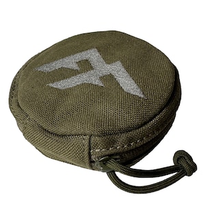 Op de afbeelding: Olijfgroene ronde etui met een zilveren geborduurd logo. De etui heeft een ritssluiting en een geknoopt koord. De stof heeft een getextureerde uitstraling. Ontworpen voor kleine items.