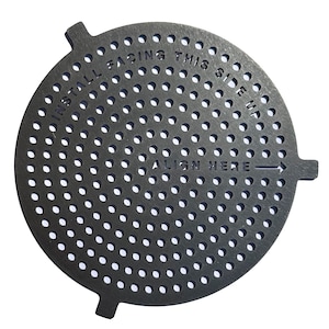 May include: A circular, dark grey metal component with many small perforations. The text "INSTALL FACING THIS SIDE UP" and "ALIGN HERE" with an arrow are etched on the surface. It has three small tabs extending from the edge.