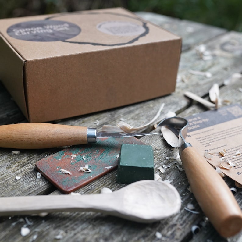May include: A wood carving kit with a wooden spoon, carving tools, a sharpening stone, and a green sanding block. The kit comes in a brown cardboard box with the words "Green Wood Carving" printed on the top.