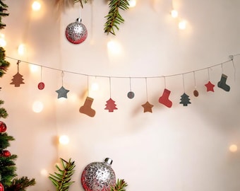 May include: A festive Christmas garland with a string of lights, featuring various ornaments including stars, trees, and stockings. The garland is made of burlap and has a rustic, farmhouse style.