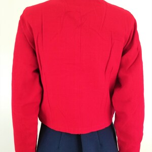May include: A red cropped jacket with long sleeves.