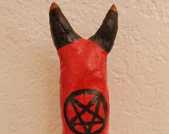 Devilish, handmade penis-shaped clay sculpture