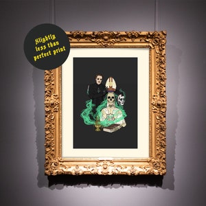 May include: A framed print of a black and white illustration of a band in a dark setting. The band members are wearing black clothing and have a skeletal appearance. The illustration is surrounded by green smoke.