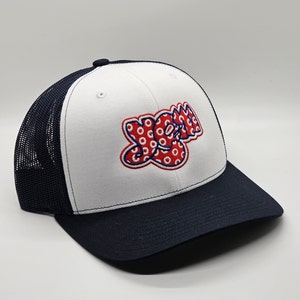 May include: White and navy blue trucker hat with a red and white "Yo Mom" logo with a polka dot pattern.